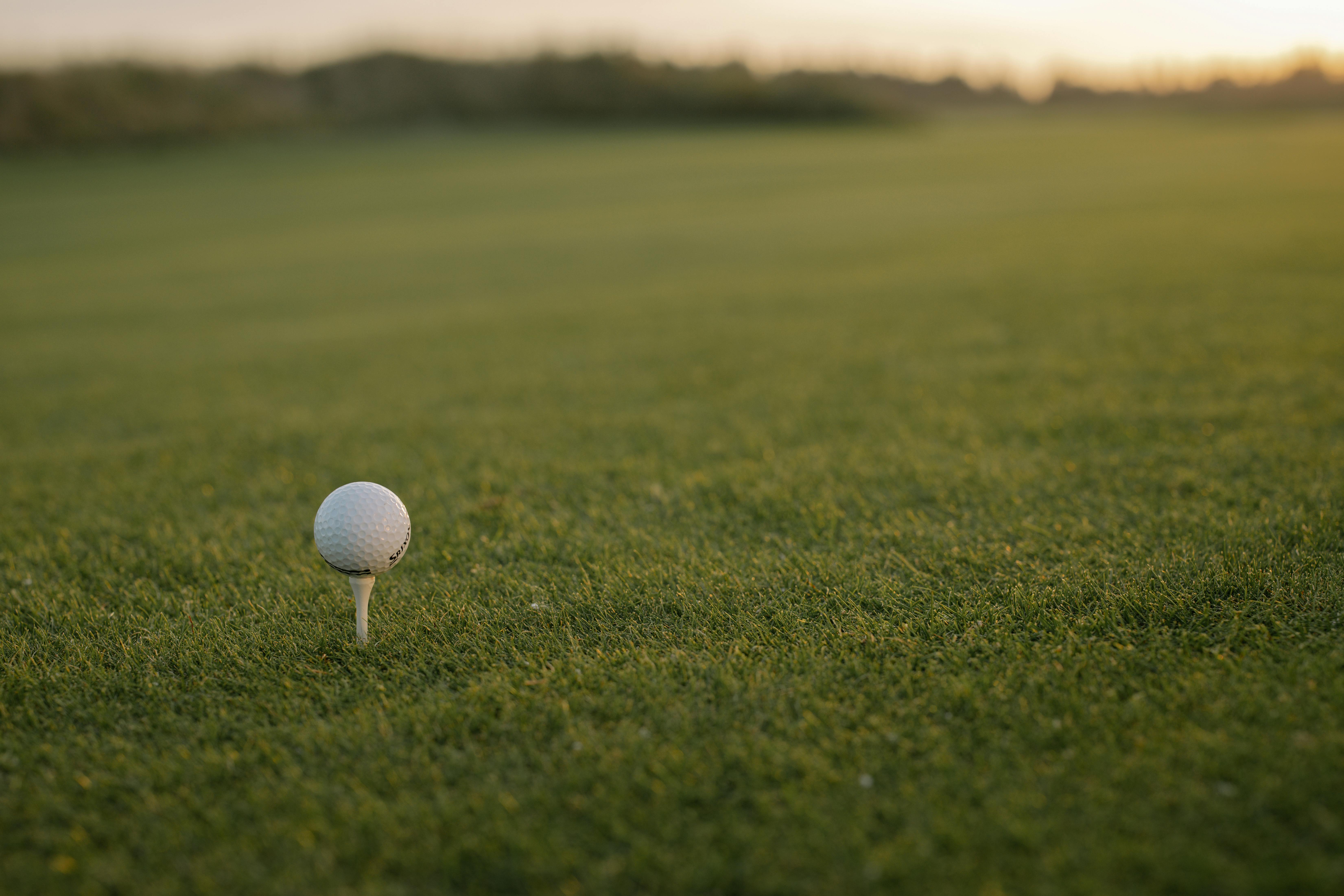 Golf ball on tee on golf course green